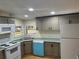 Bright kitchen featuring gray cabinets, modern appliances, laminate countertops, and hardwood floors at 622 Dreama Dr, Davenport, FL 33897