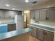 This kitchen features gray cabinets, modern appliances, laminate countertops, hardwood floors, and a blue dishwasher at 622 Dreama Dr, Davenport, FL 33897