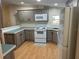 A well-lit kitchen features two-tone cabinets, a white electric range, and plenty of counter space at 622 Dreama Dr, Davenport, FL 33897