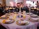 Elegant banquet hall table setting with gold chargers, crystal centerpiece, and soft pink accents at 6337 Parc Corniche Dr # 2311, Orlando, FL 32821