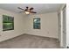 Neutral bedroom with two windows, closet, carpet flooring, and ceiling fan at 6421 Nw 61St St, Ocala, FL 34482