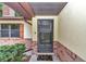 Close-up of front door with security screen and 'Hello' welcome mat on a brick porch at 6421 Nw 61St St, Ocala, FL 34482