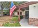 Inviting covered front porch with brick accents, decorative shutters, and an American flag at 6421 Nw 61St St, Ocala, FL 34482