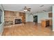 Spacious living room with wood floors, stone fireplace, and an open layout to the kitchen at 6421 Nw 61St St, Ocala, FL 34482