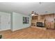 Cozy living room featuring wood floors, a stone fireplace, and ample natural light at 6421 Nw 61St St, Ocala, FL 34482