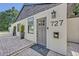 Home's inviting front entrance has black house number and stylish gray door with brick paver patio and decor at 727 Seminole Ave, Orlando, FL 32804