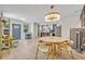 Open-concept living space with modern light fixture, dining area, and updated kitchen featuring sleek countertops at 727 Seminole Ave, Orlando, FL 32804