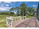 Backyard brick patio with stone railing overlooking lush lawn and a serene view of the water at 736 Timacuan Blvd, Lake Mary, FL 32746