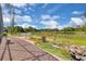 Backyard brick patio with stone railing overlooking the water, a landscaped garden, and clear blue skies at 736 Timacuan Blvd, Lake Mary, FL 32746