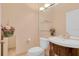 Elegant powder room featuring a modern vanity with glass shelves, flower accents, and wallpapered accents at 736 Timacuan Blvd, Lake Mary, FL 32746
