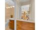 Stylish powder room showcasing wood vanity, decorative mirror, and a sink with gold fixtures, with flower accents at 736 Timacuan Blvd, Lake Mary, FL 32746