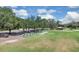 Golfers practicing on a well-maintained driving range surrounded by mature trees, with golf carts parked nearby at 736 Timacuan Blvd, Lake Mary, FL 32746