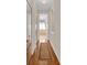 Hallway with wood floors leads to a bath with a large window for natural light at 736 Timacuan Blvd, Lake Mary, FL 32746