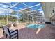 Screened-in pool area with patterned brick, ample seating, and a serene view of the water and lush greenery at 736 Timacuan Blvd, Lake Mary, FL 32746