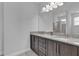 Bathroom featuring double sinks with granite countertop and dark cabinets for a modern aesthetic at 7524 Marker Ave, Kissimmee, FL 34747