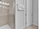Tiled shower with glass door, white towels on rack, and tiled flooring create a clean bathroom at 7524 Marker Ave, Kissimmee, FL 34747