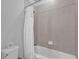 Cozy bathroom with bathtub and shower, featuring neutral tiling and white fixtures at 7524 Marker Ave, Kissimmee, FL 34747