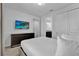 Neat bedroom featuring dresser with TV, white walls, and ensuite bathroom at 7524 Marker Ave, Kissimmee, FL 34747