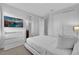 Crisp white bedroom with a modern dresser, large doors, and minimalist decor creating a serene atmosphere at 7524 Marker Ave, Kissimmee, FL 34747