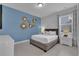 Modern bedroom features a blue accent wall, stylish gold art, and light gray carpet at 7524 Marker Ave, Kissimmee, FL 34747