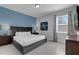 Comfortable bedroom featuring a king-sized bed, stylish blue accent wall, and ample natural light at 7524 Marker Ave, Kissimmee, FL 34747