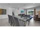 Open-concept dining area with seating for ten, connecting to the living room and outdoor patio at 7524 Marker Ave, Kissimmee, FL 34747