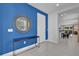 Stylish entryway with blue accent wall, round mirror, and console table, providing a welcoming feel at 7524 Marker Ave, Kissimmee, FL 34747