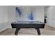 Air hockey table sits on a carpeted floor under modern art in this bonus room at 7524 Marker Ave, Kissimmee, FL 34747