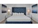 Luxurious bedroom with plush blue headboard, white bedding, and bedside tables with lamps at 7524 Marker Ave, Kissimmee, FL 34747