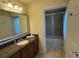 Bathroom featuring sink with granite top, large mirror, decorative lighting, and glass shower at 7651 Whisper Way # 201, Kissimmee, FL 34747