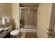 Bathroom showcasing tub-shower combo with glass door, toilet, and neutral finishes at 7651 Whisper Way # 201, Kissimmee, FL 34747