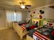 Charming bedroom featuring three beds, a ceiling fan, and a delightful Mickey Mouse mural at 7651 Whisper Way # 201, Kissimmee, FL 34747