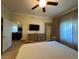 Relaxing bedroom featuring a ceiling fan, dresser, and large window for natural light at 7651 Whisper Way # 201, Kissimmee, FL 34747