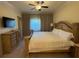 Well-lit bedroom featuring a ceiling fan, dresser, and large window at 7651 Whisper Way # 201, Kissimmee, FL 34747