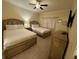 Comfortable bedroom showcasing two beds, a ceiling fan, dresser, and soft natural light at 7651 Whisper Way # 201, Kissimmee, FL 34747