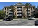 Beautiful multi-story building featuring tropical landscaping and a convenient parking area at 7651 Whisper Way # 201, Kissimmee, FL 34747