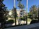 Scenic view of building surrounded by lush landscaping, palm trees, and a well-maintained walking path at 7651 Whisper Way # 201, Kissimmee, FL 34747