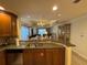 The open kitchen has granite countertops, wood cabinets, and a view into the expansive dining and living area at 7651 Whisper Way # 201, Kissimmee, FL 34747