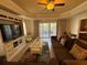 Open-concept living room with elegant finishes, hardwood floors, and a view to the balcony at 7651 Whisper Way # 201, Kissimmee, FL 34747