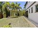 Lush backyard with manicured lawn, mature landscaping, and a beautiful stone patio at 8113 Via Vittoria Way, Orlando, FL 32819