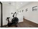 Upstairs hallway featuring an exercise bike, hardwood floors, and natural light at 8113 Via Vittoria Way, Orlando, FL 32819