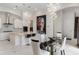 Bright and open-concept kitchen featuring stainless appliances, white cabinets, and an eat-in island under unique lighting at 8113 Via Vittoria Way, Orlando, FL 32819