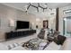 Open-concept living area with a large TV, unique lighting, and seating arrangement at 8113 Via Vittoria Way, Orlando, FL 32819