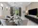 Stylish living room featuring modern furniture, large TV, and outdoor views at 8113 Via Vittoria Way, Orlando, FL 32819