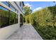 A stone patio lined with shrubbery provides an elegant outdoor space for relaxing and entertaining at 8113 Via Vittoria Way, Orlando, FL 32819