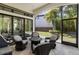 The covered, screened-in patio has comfortable seating and access to the living room and backyard at 8113 Via Vittoria Way, Orlando, FL 32819