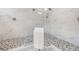 Close up on frameless shower featuring dual shower heads, corner bench, and tiled floor at 8113 Via Vittoria Way, Orlando, FL 32819