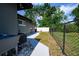 Backyard with a gray home exterior, chain link fence, and a concrete walkway for easy access at 874 Brevard Ct, Orlando, FL 32822