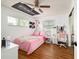Bedroom featuring pink bedding, wood flooring, windows with blinds, and overhead fan at 874 Brevard Ct, Orlando, FL 32822