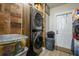 Modern laundry area featuring a stacked washer and dryer set and wooden accent wall at 874 Brevard Ct, Orlando, FL 32822